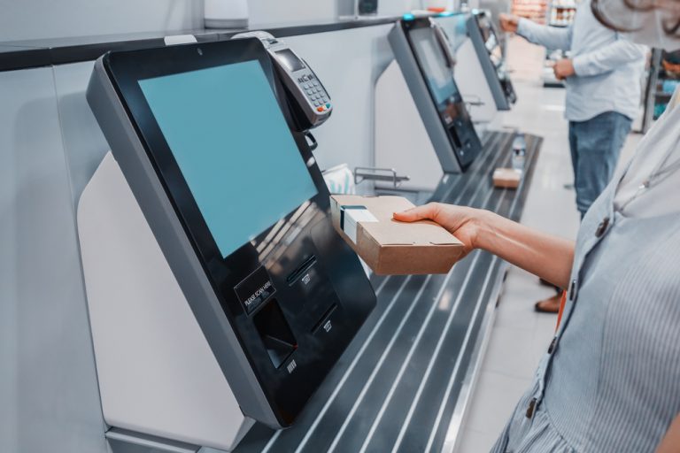 Someone scanning a food item at a self-service kiosk station.