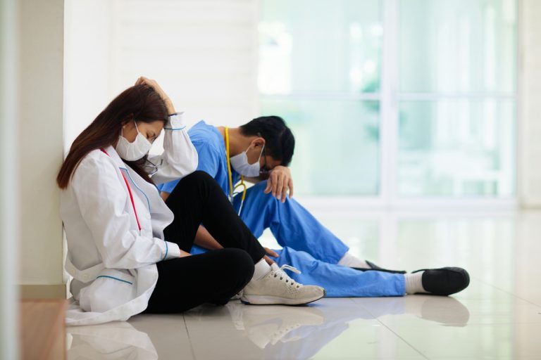 Tired and overworked nurses sitting to rest.