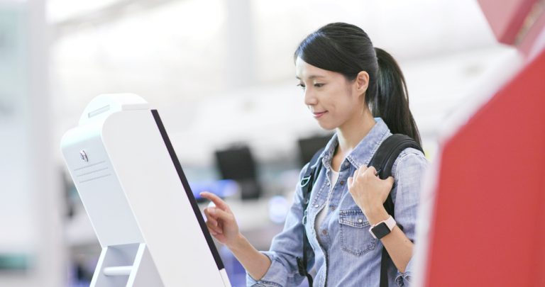 Woman using a kiosk machine.