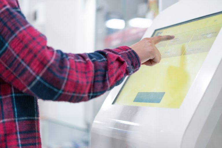 Young man using a self-service kiosk.